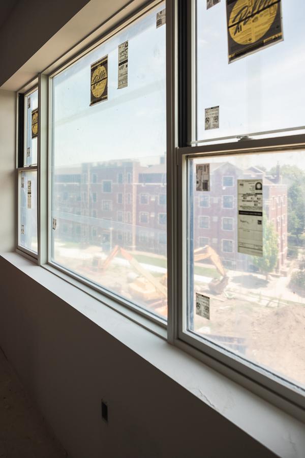 A window on the third floor of the residence hall overlooks construction equipment and Smith Hall. 