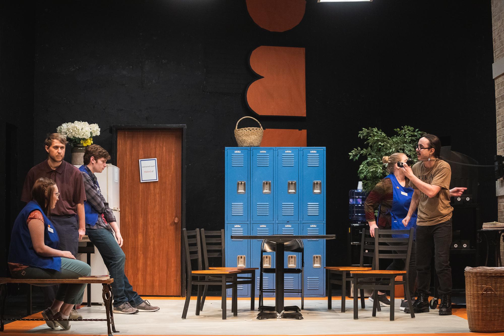 Image of the set and cast of Doane's production of "A Bright New Boise." The majority of the play takes place in the break room of a large arts and crafts store in Idaho.