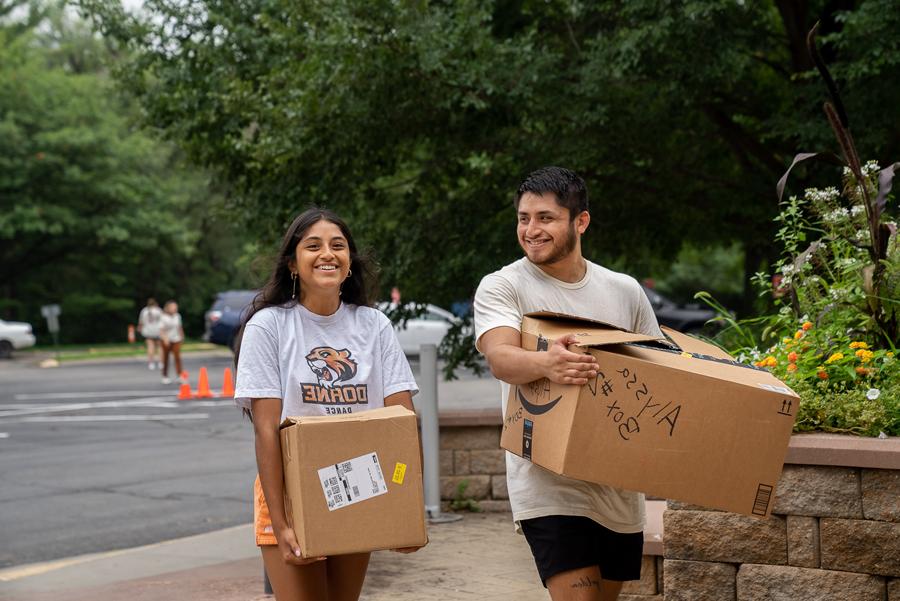 Doane大四学生Arturo Salinas帮助他的妹妹, 阿莉莎, 在大学一年级学生入住当天，把箱子搬进宿舍. 
