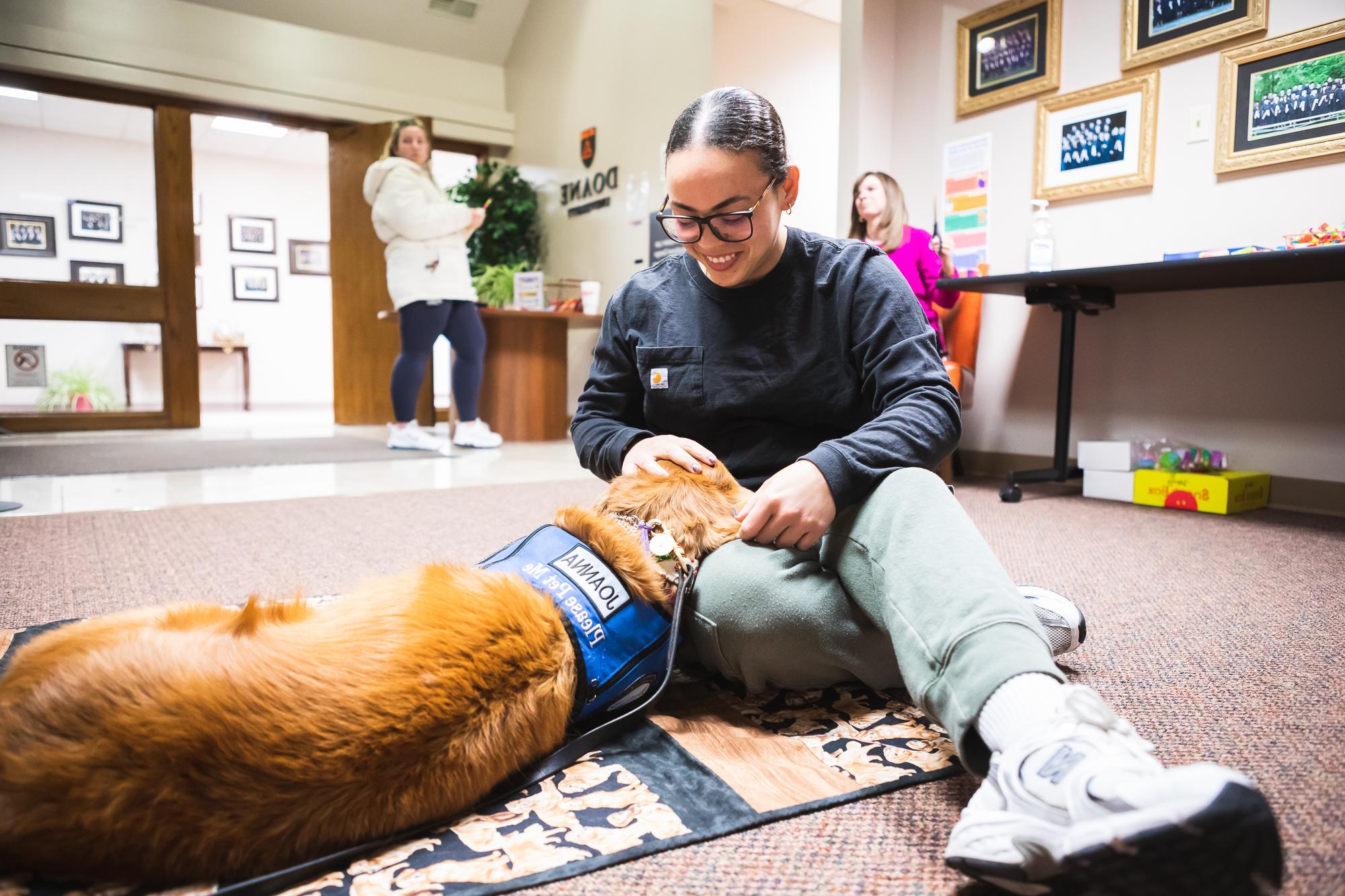 心理咨询艺术硕士学生Ekianet Tamayo宠物乔安娜, a trained therapy dog, 在林肯的课间休息时.