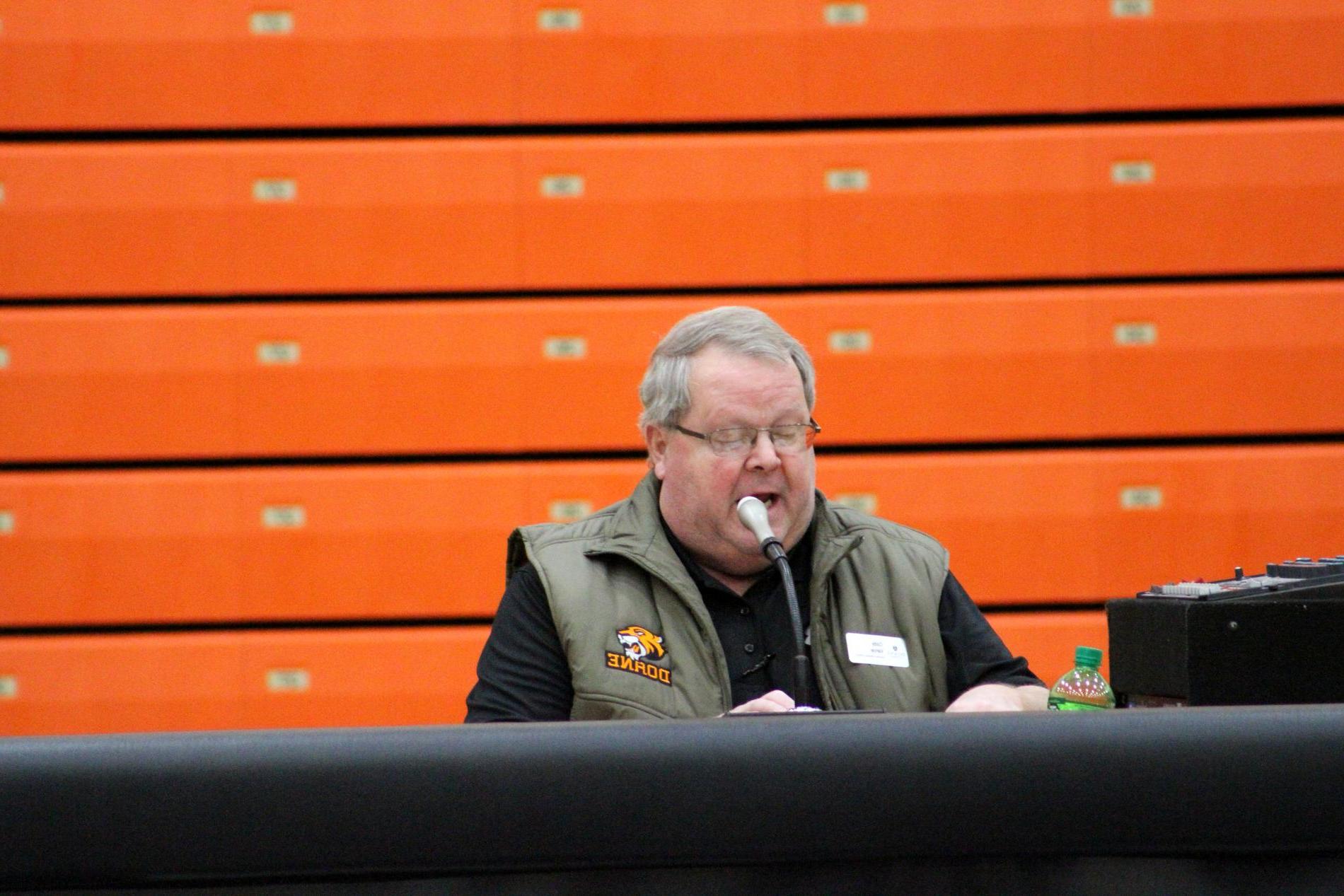 Cody Vance sits behind a mic at Haddix as the public address announcer at Doane University 