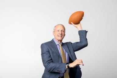 Dr. Roger Hughes holds a pose like he's about to throw a football.