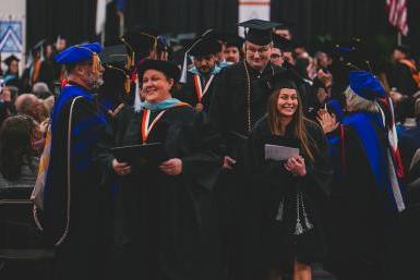 Two lines of Doane administrators and faculty cheer on newly minted graduates at the end of the winter commencement ceremony, held Saturday, Dec. 17. 