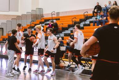 Members of the Doane men's basketball team congratulate a fellow student for making a half-court shot during a halftime challenge.